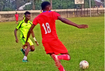 man kicking the soccer ball in soccer field